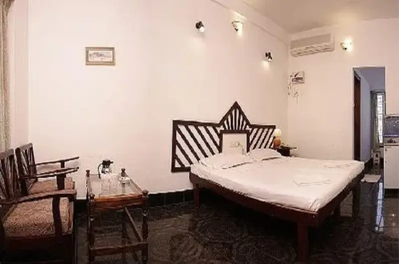 Deluxe twin bedroom setup with warm indoor lighting at Raja Hotel Kovalam