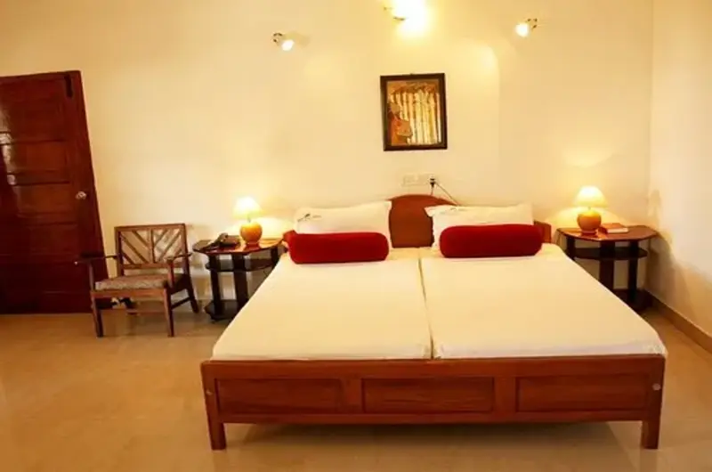 Spacious double bedroom with neat bed linens at Raja Hotel Kovalam Kerala