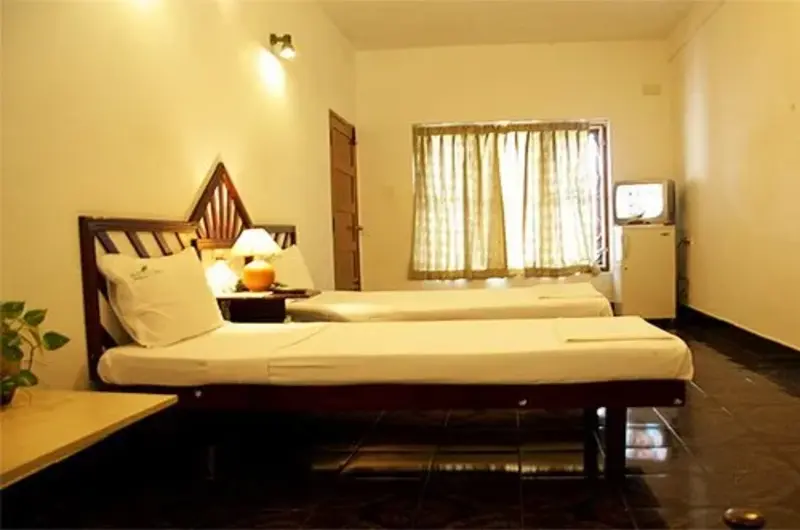 Executive guest room with large window and seating area at Raja Hotel Kovalam