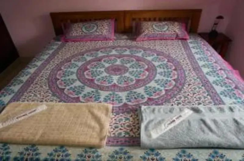 Deluxe double bedroom with vibrant patterned bed linens at Padmini House Kovalam