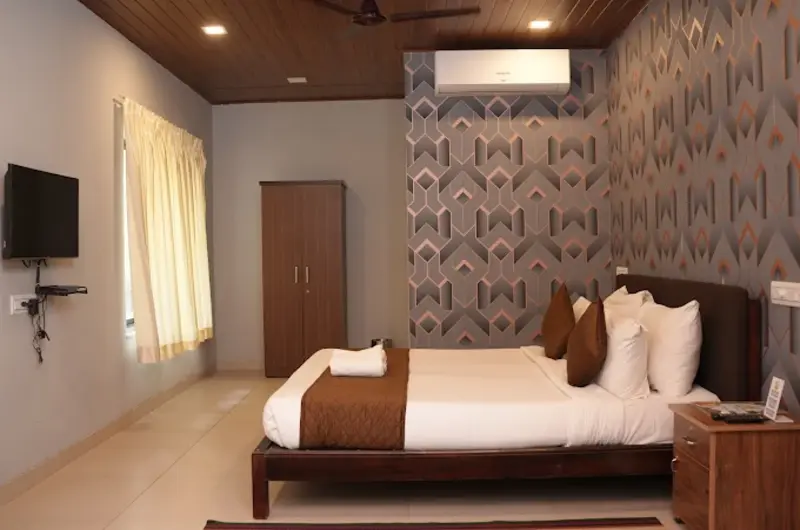 Premium air conditioned guest room setup with wooden paneling at Country Club Kovalam Beach