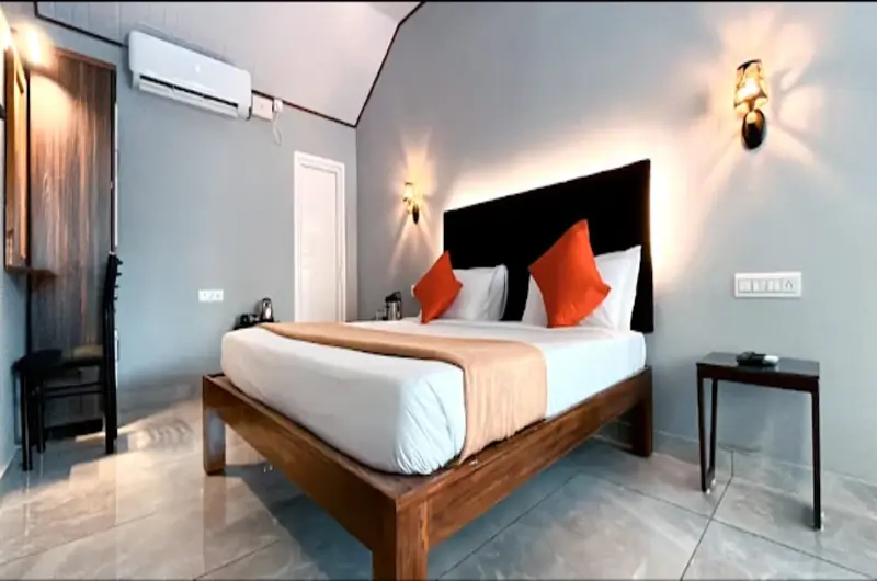 Modern deluxe double bedroom interior with elegant lighting at Country Club Kovalam Beach