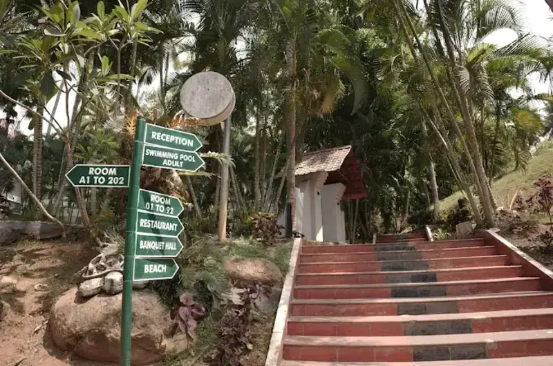 Country Club Kovalam Beach resort entrance pathway surrounded by palm trees