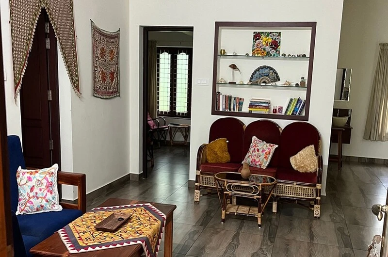 Traditional living room interior with wooden furniture and decor at Laures House homestay in Kovalam