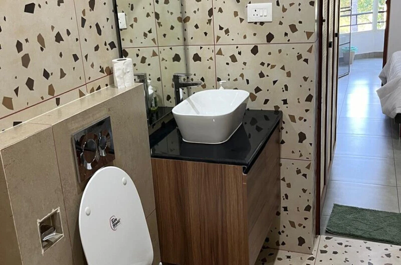 Clean modern bathroom interior with a contemporary vanity sink and mirror at Sobha Mandiram