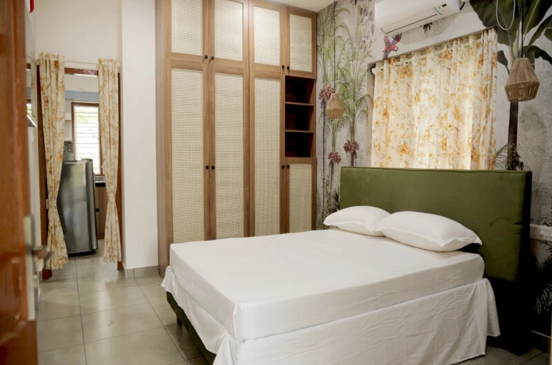 Spacious double bedroom with minimalist decor and clean linens at Sobha Mandiram Kovalam