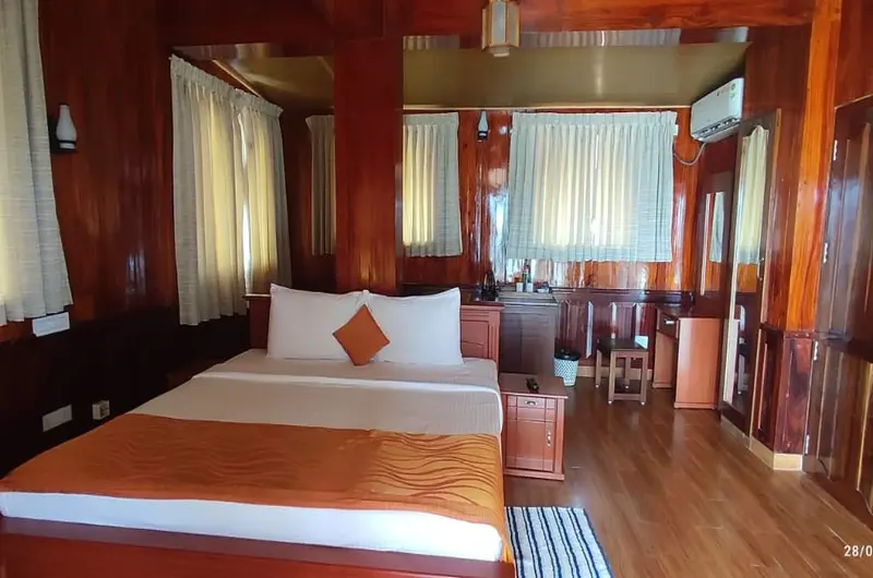 Comfortable double bedroom with clean white linens and warm lighting at Thayil Kadaloram Homestay Kovalam