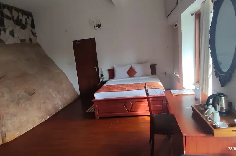 Bright and spacious double bedroom setup with warm wooden flooring at Thayil Kadaloram Homestay Kovalam