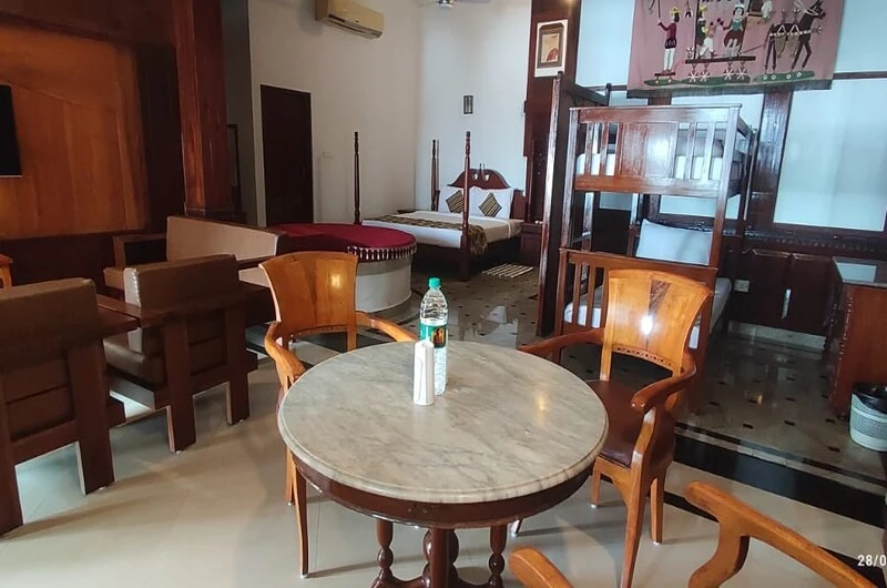 Well-lit dining room setup featuring a round wooden dining table at Thayil Kadaloram Homestay Kovalam
