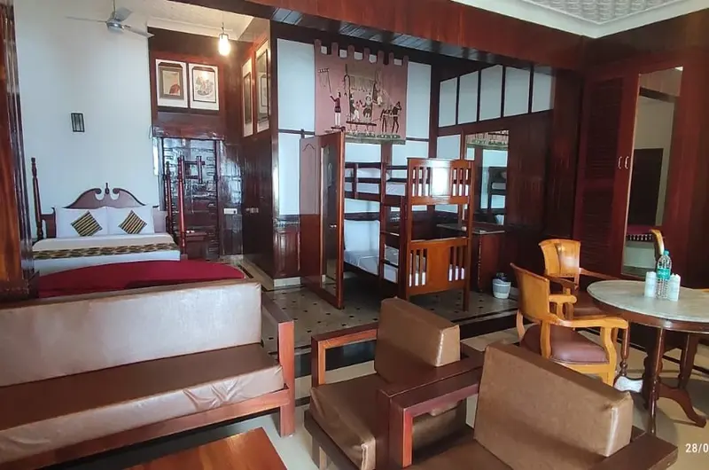 Spacious indoor living room with traditional wooden furniture at Thayil Kadaloram Homestay Kovalam