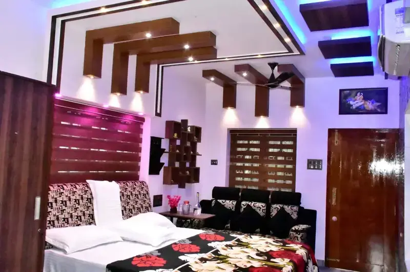 Comfortable double bedroom with contemporary wooden wall panels and purple ambient lights
