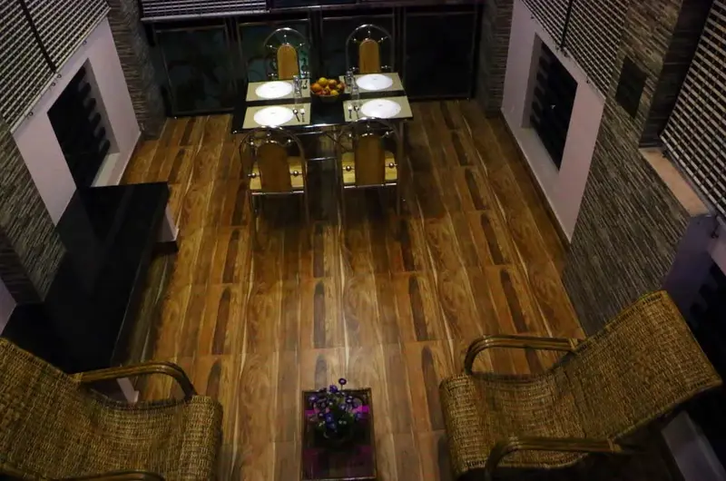 Top-angle view of a wooden dining table setup in a homestay common area