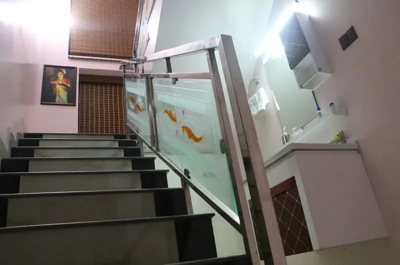 Indoor tiled staircase with modern glass railing at Mary Land Homestay