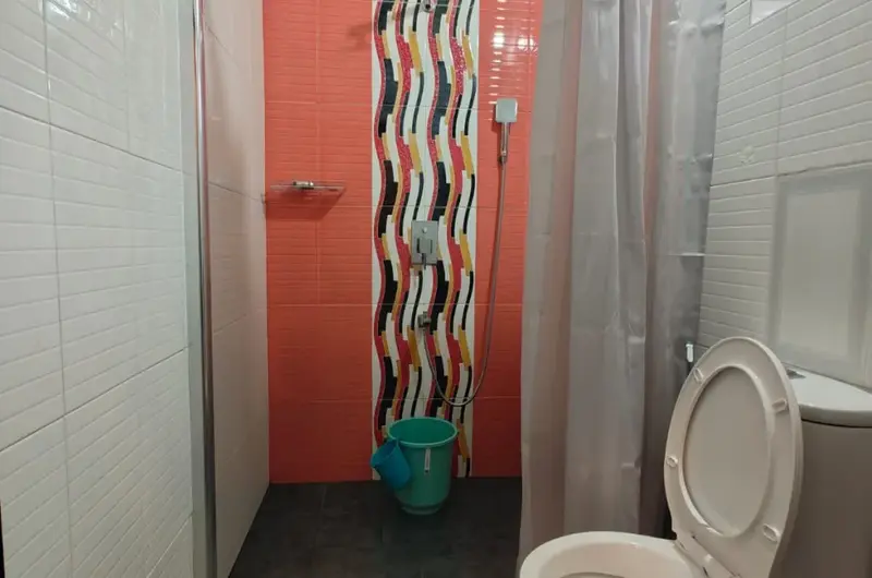 Neat and modern attached bathroom setup at Therickal Homes Homestay Kovalam.