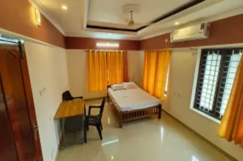 Spacious boutique guest bedroom featuring twin beds and minimalist interiors at Therickal Homes.