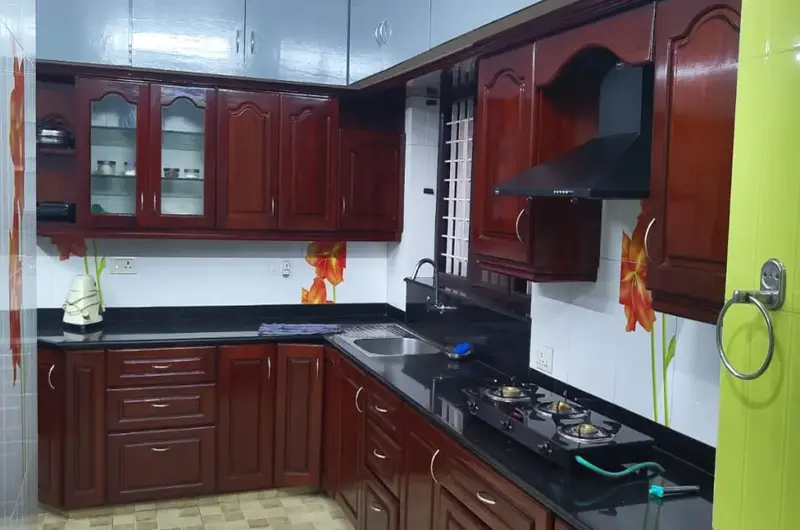 Well-equipped modular kitchen interior with premium wooden cabinets at Therickal Homes.