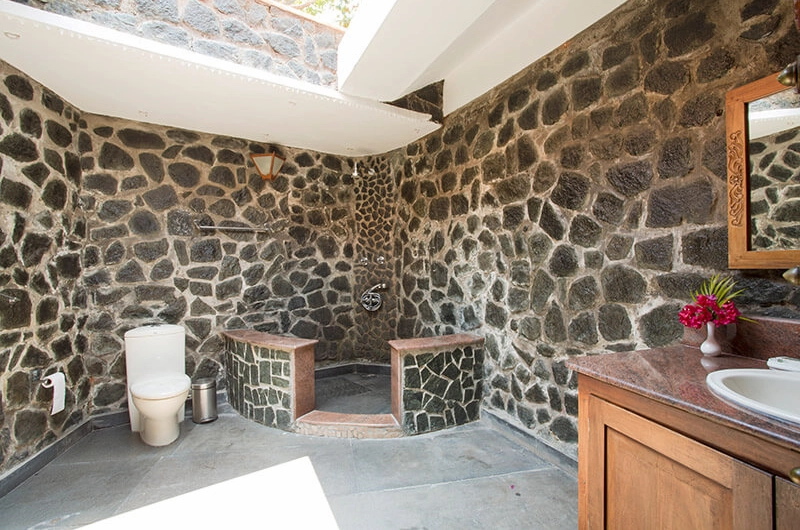 Rustic stone wall bathroom with shower at Somatheeram Ayurvedic Health Resort Kovalam