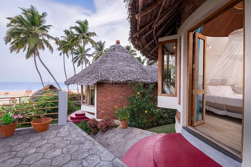 Open air thatched gazebo overlooking Arabian Sea coastline at Somatheeram Ayurvedic Health Resort Kovalam
