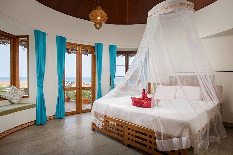 Comfortable cottage bedroom with four poster bed at Somatheeram Ayurvedic Health Resort