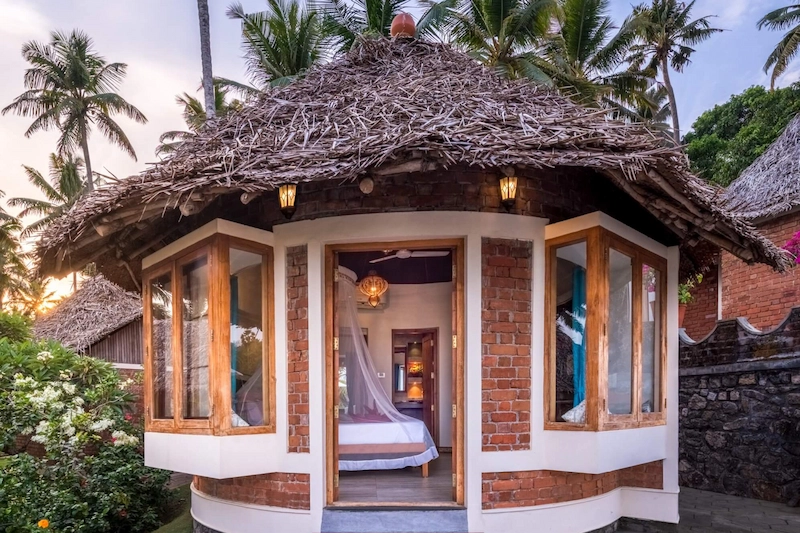 Traditional Kerala style cottage with carved wooden architecture at Somatheeram Ayurvedic Health Resort