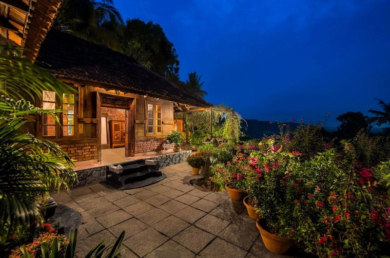 Evening view of illuminated stone pathway leading to cottages at Somatheeram Ayurvedic Health Resort