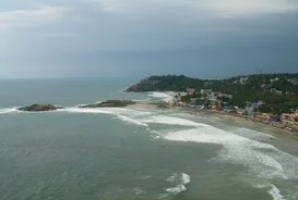 Aerial view of ocean waves crashing against the rocky Edakkalu foreland promontory at Hawa Beach Kovalam