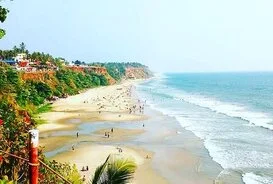 Aerial view of ocean waves crashing along the sandy shores of Varkala Beach near Kovalam